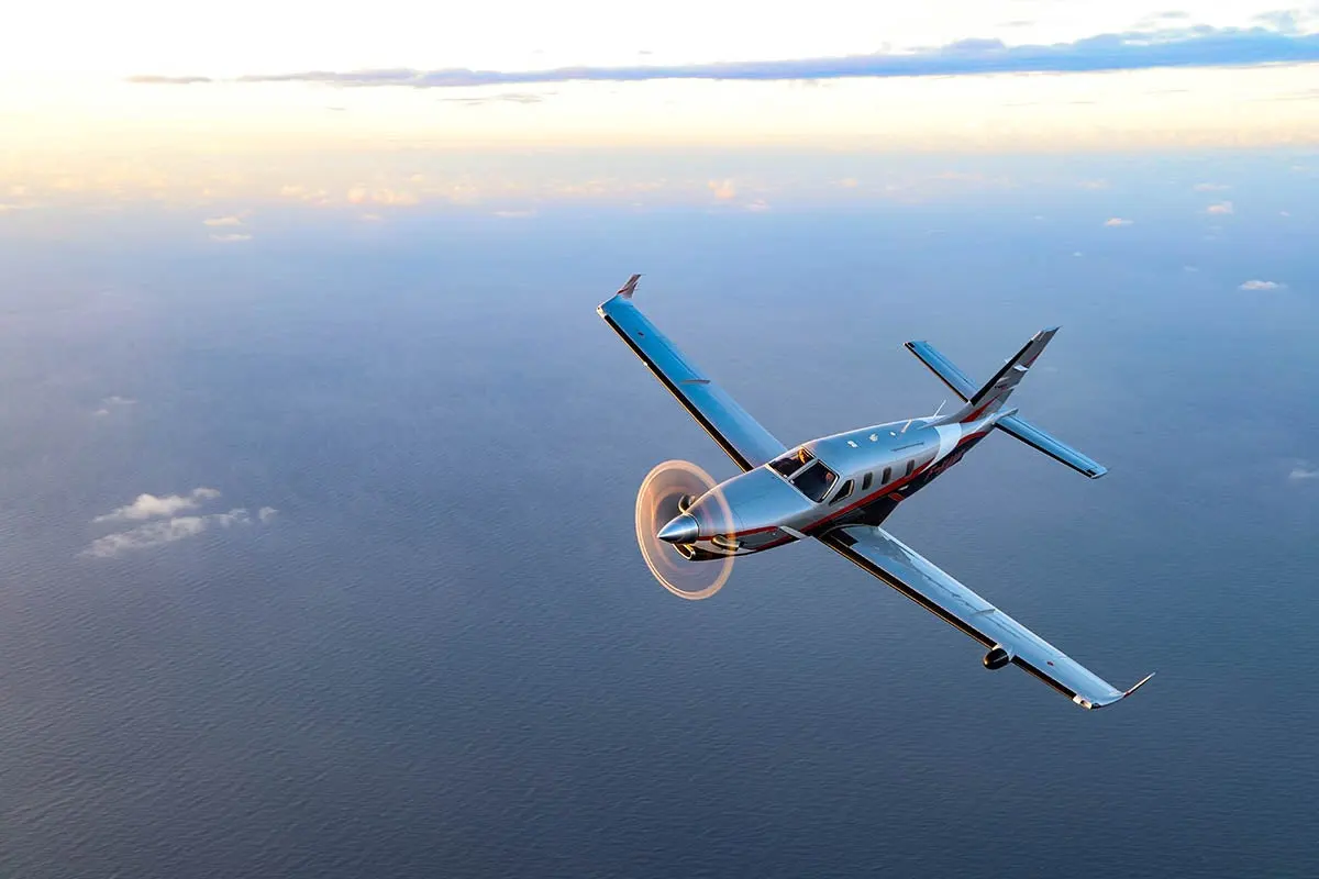 Daher TBM in flight over the ocean &mdash; single-engine turboprop