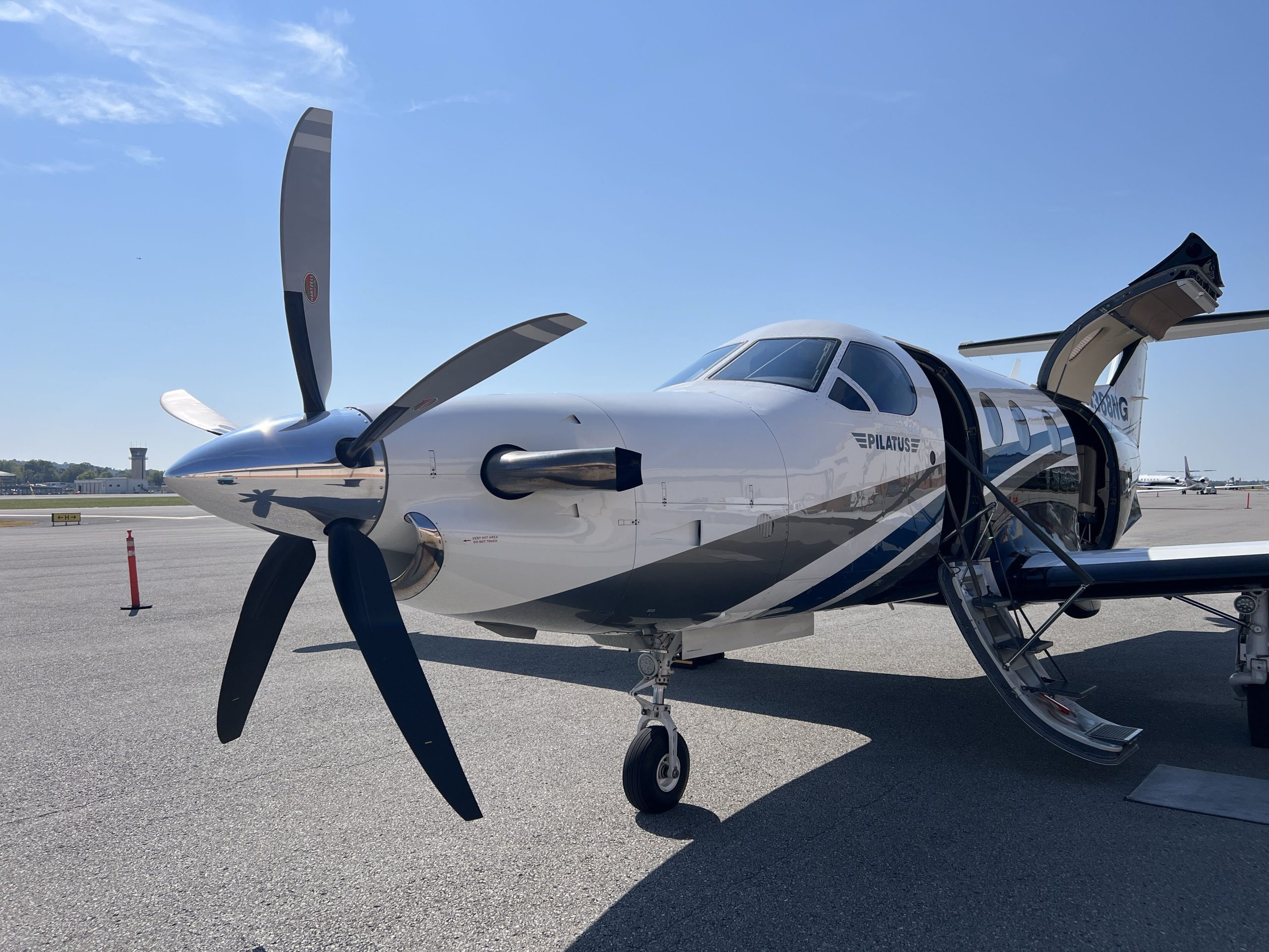 Pilatus PC-12 on the ramp with the cabin door and airstairs open, propeller in the foreground